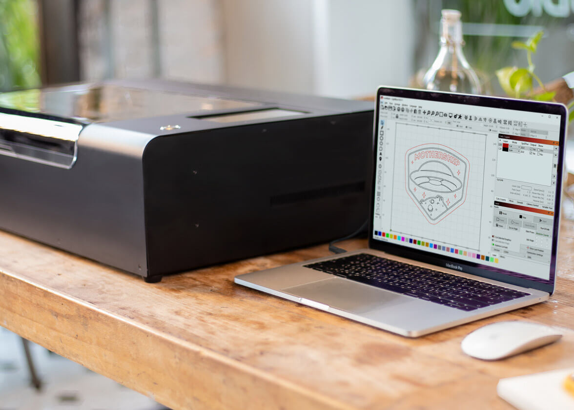 LightBurn na laptopu pored Beamo uređaja na drvenom stolu.