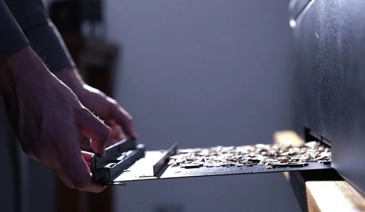 Osoba otvara fioku za čišćenje na FLUX HEXA, puna otpadnog materijala.